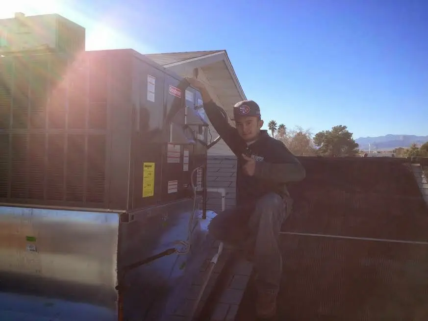 HVAC technician performing HVAC Inspection on a rooftop unit in El Reno